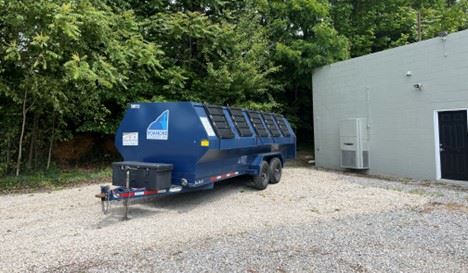 Mount Pleasant Recycling Trailer in front of gray block garage